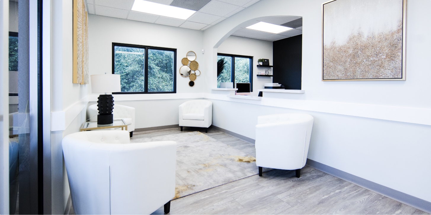 AgeDefy clinic interior — bright waiting area with white chairs and arched reception