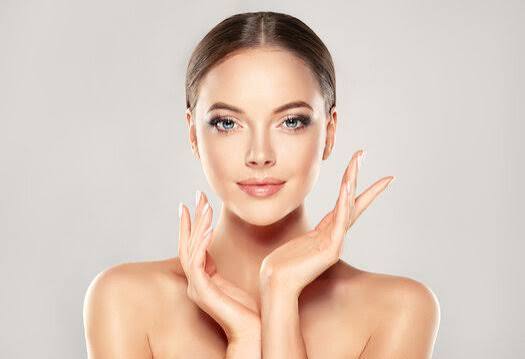 Woman with smooth, healthy skin resting her hands beside her face