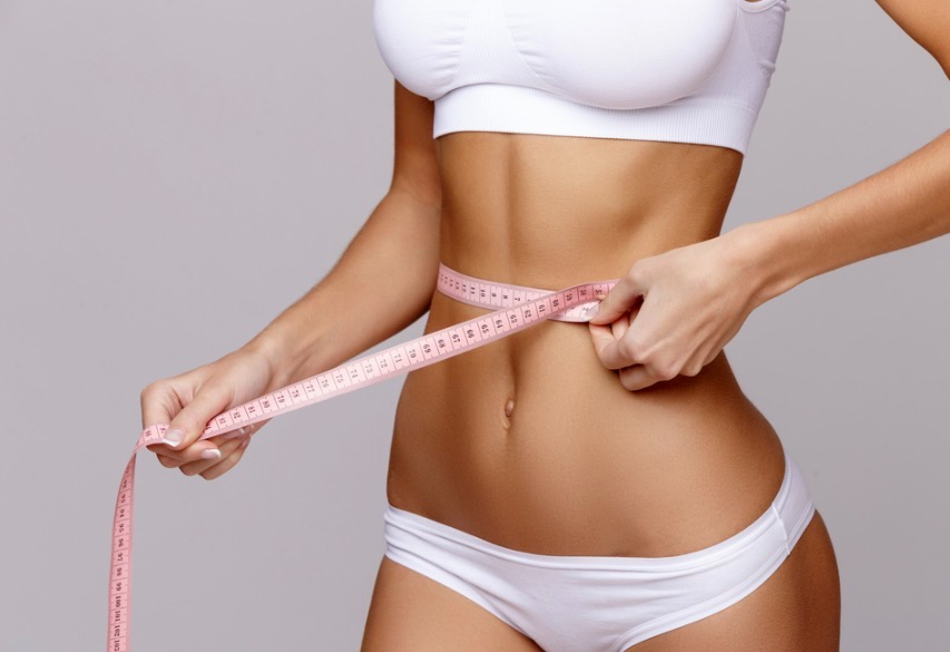Measuring tape around a toned waist